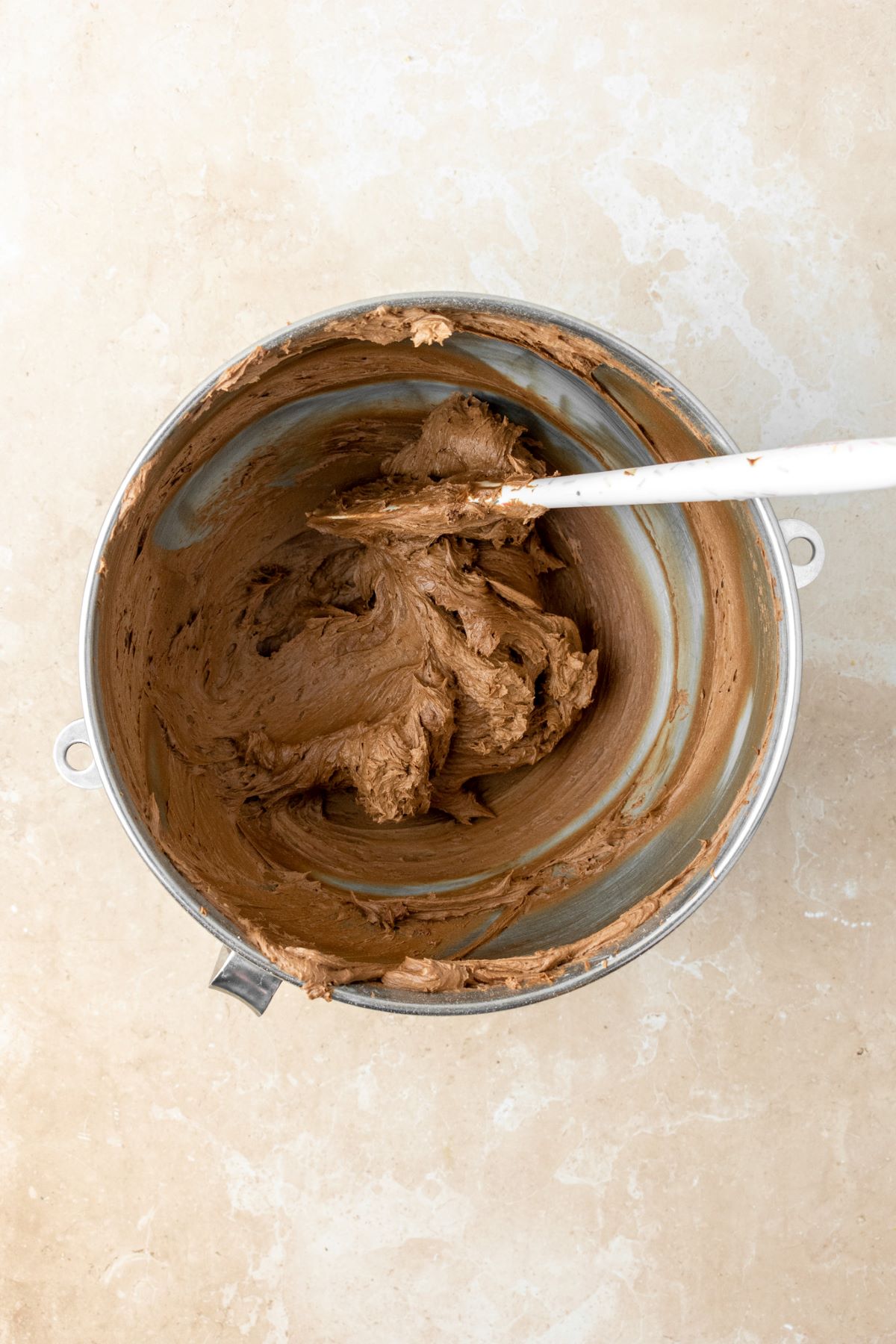 Chocolate frosting in a stainless steel bowl.