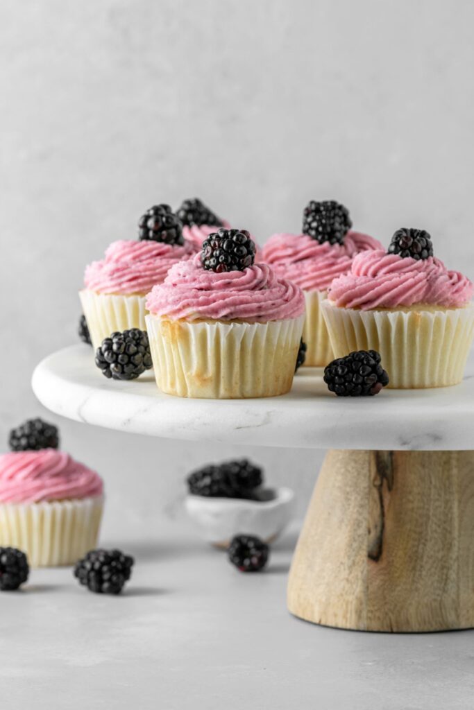 Blackberry cupcakes on a cake stand.