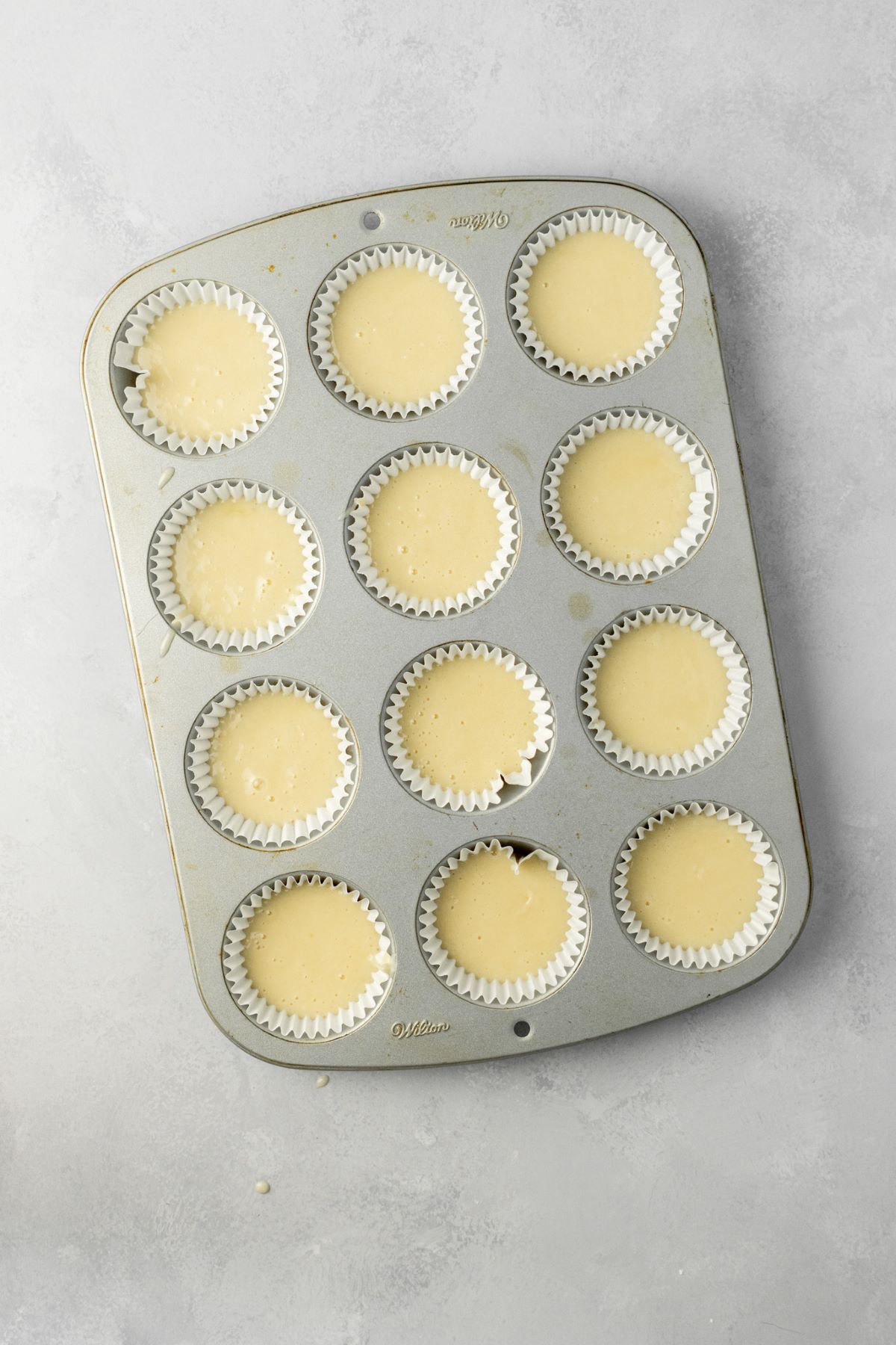 Muffin pan filled with cupcake batter.
