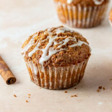 Cinnamon streusel topping on a cinnamon muffin with vanilla icing on top.