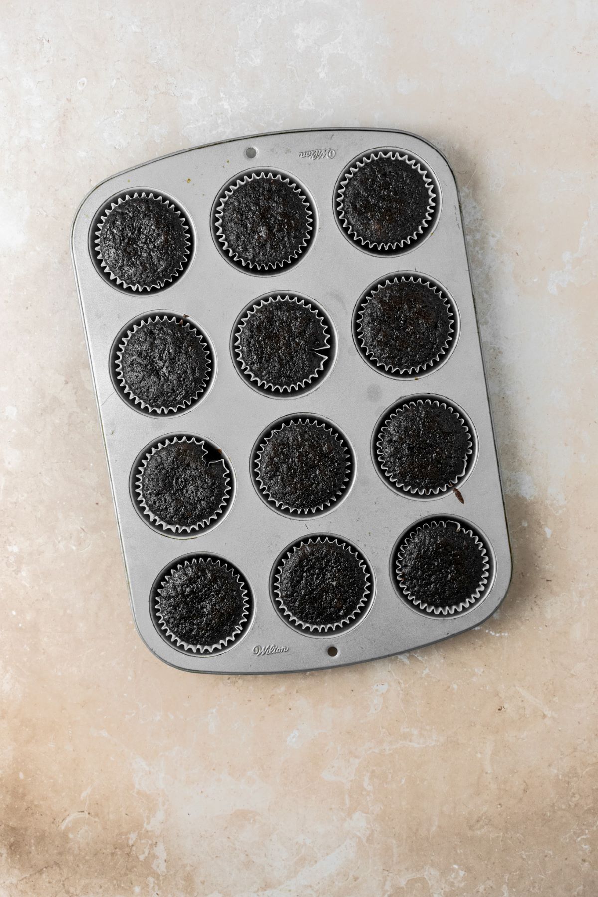 Baked chocolate cupcakes in a muffin pan.