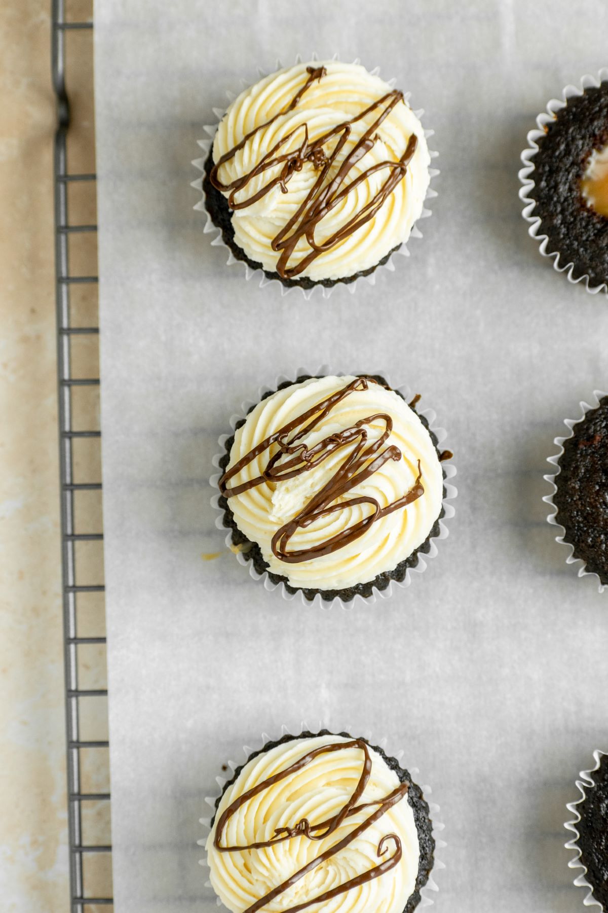 Caramel frosting and a chocolate drizzle on top of cupcakes.