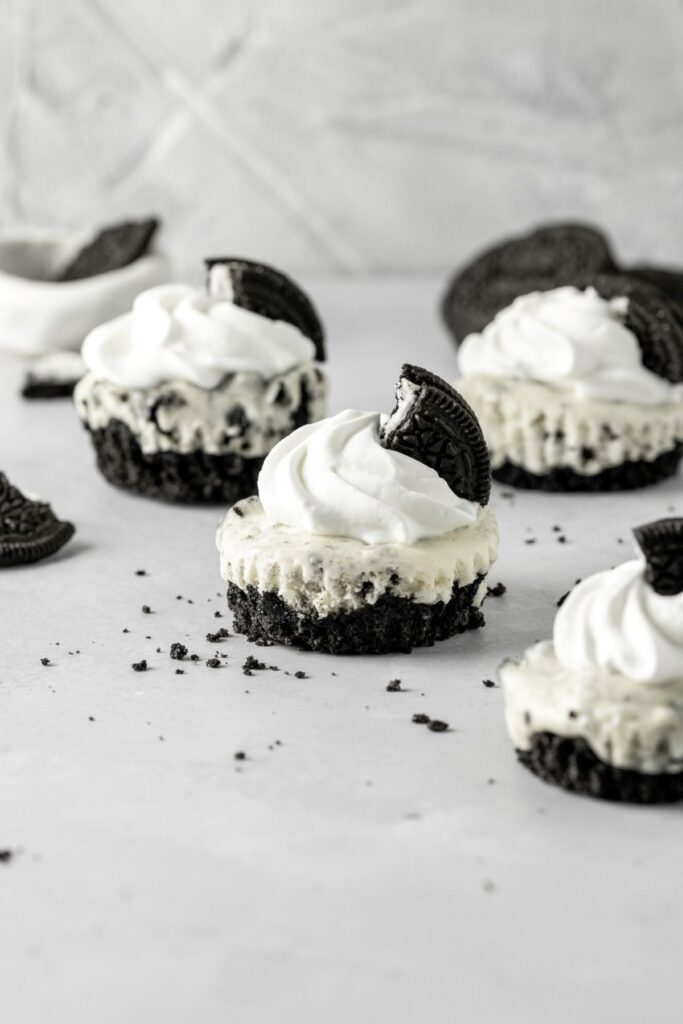Oreo cheesecakes with Oreo crumbs all over the table.