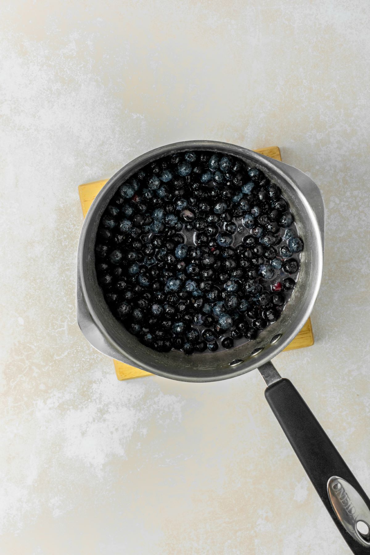 Blueberry filling cooking in a medium saucepan.