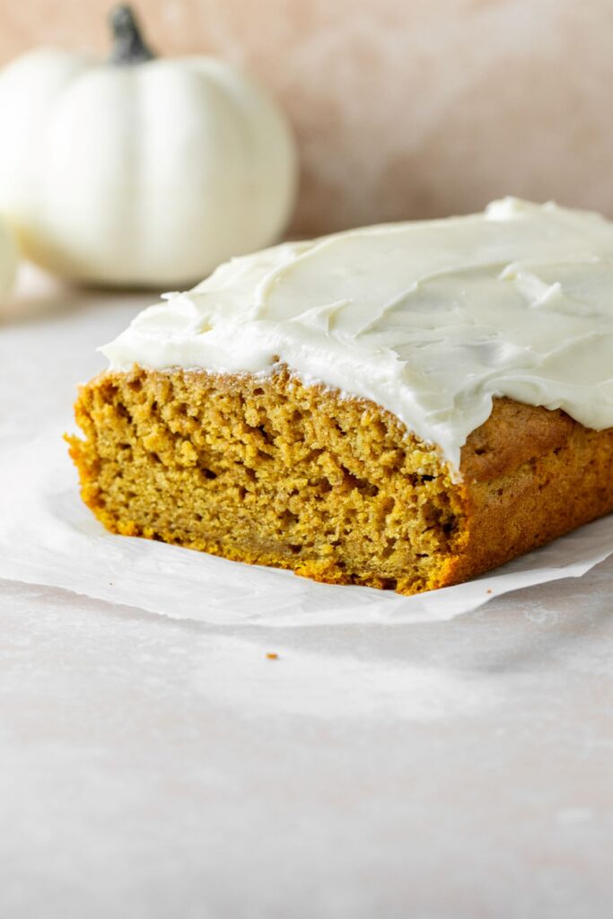 Pumpkin bread with cream cheese frosting on top.