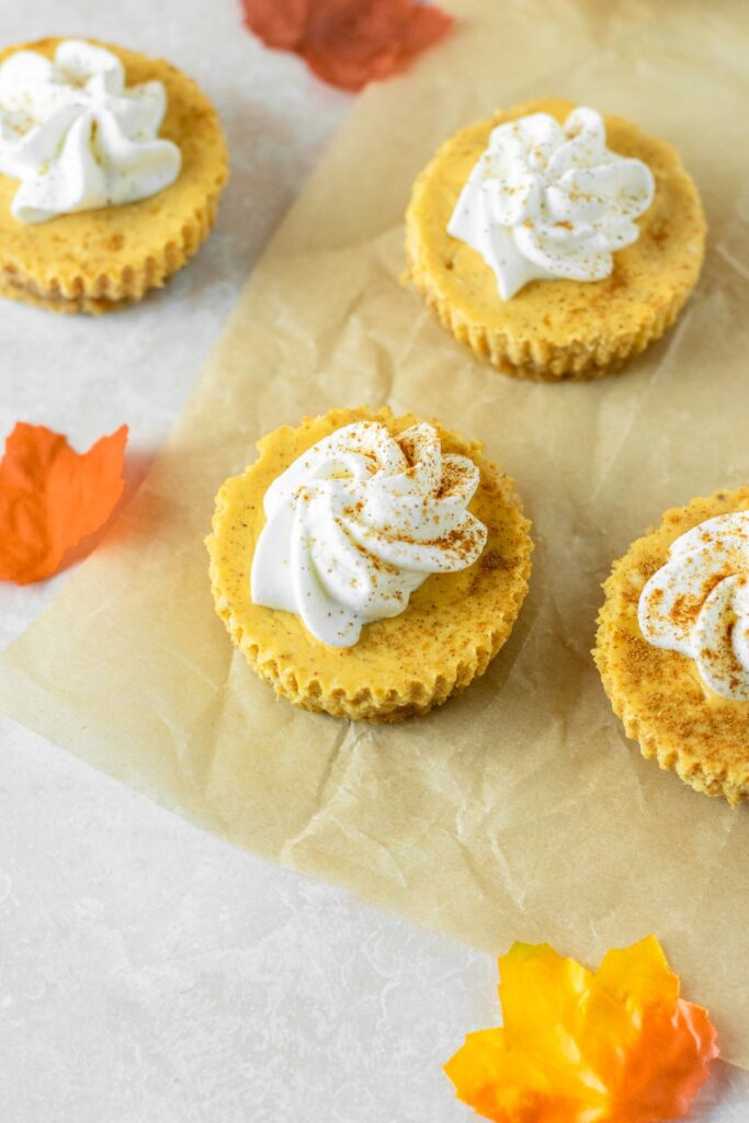 Pumpkin cheesecake bites with whipped cream on top.
