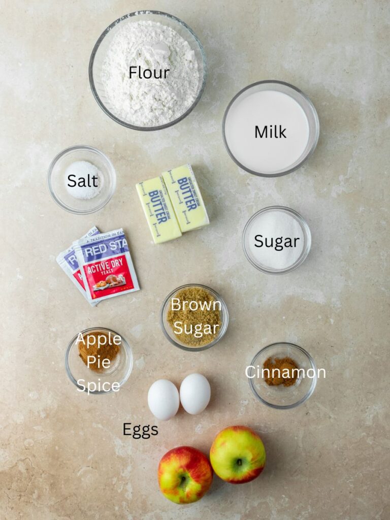 Ingredients needed: flour, milk, salt, butter, sugar, yeast, brown sugar, apple pie spice, eggs, cinnamon, and apples.