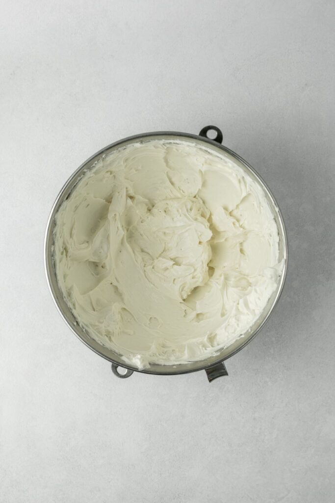 Cream cheese whipped in a stainless steel bowl.