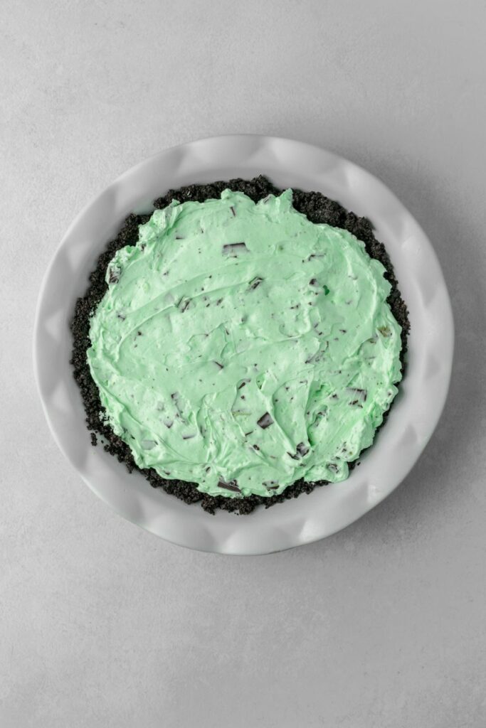 A no bake mint pie in a pie plate ready to set up in the refrigerator.