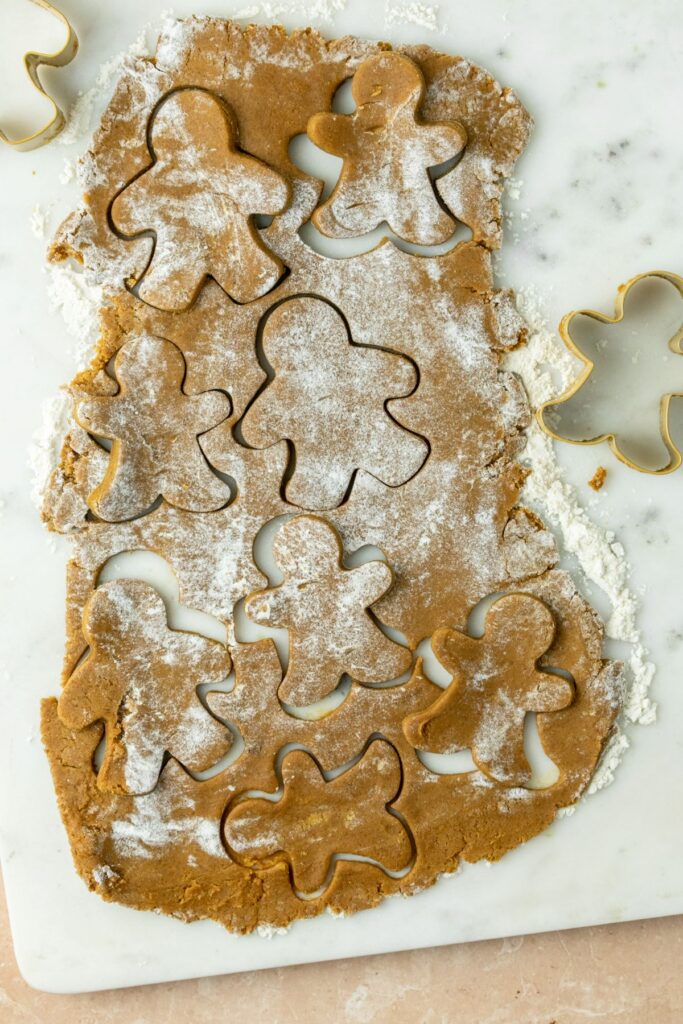 Rolled out gingerbread dough with gingerbread men cookie cutter cutouts.