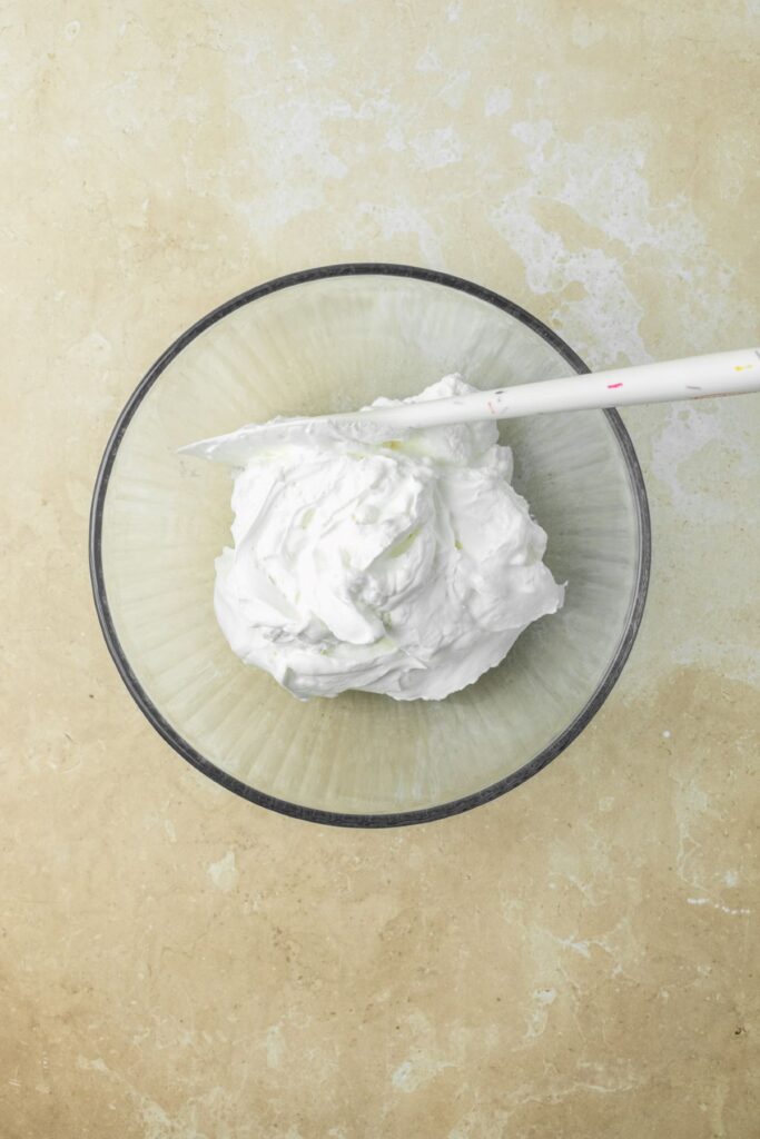 Whipped cream in a large glass bowl.