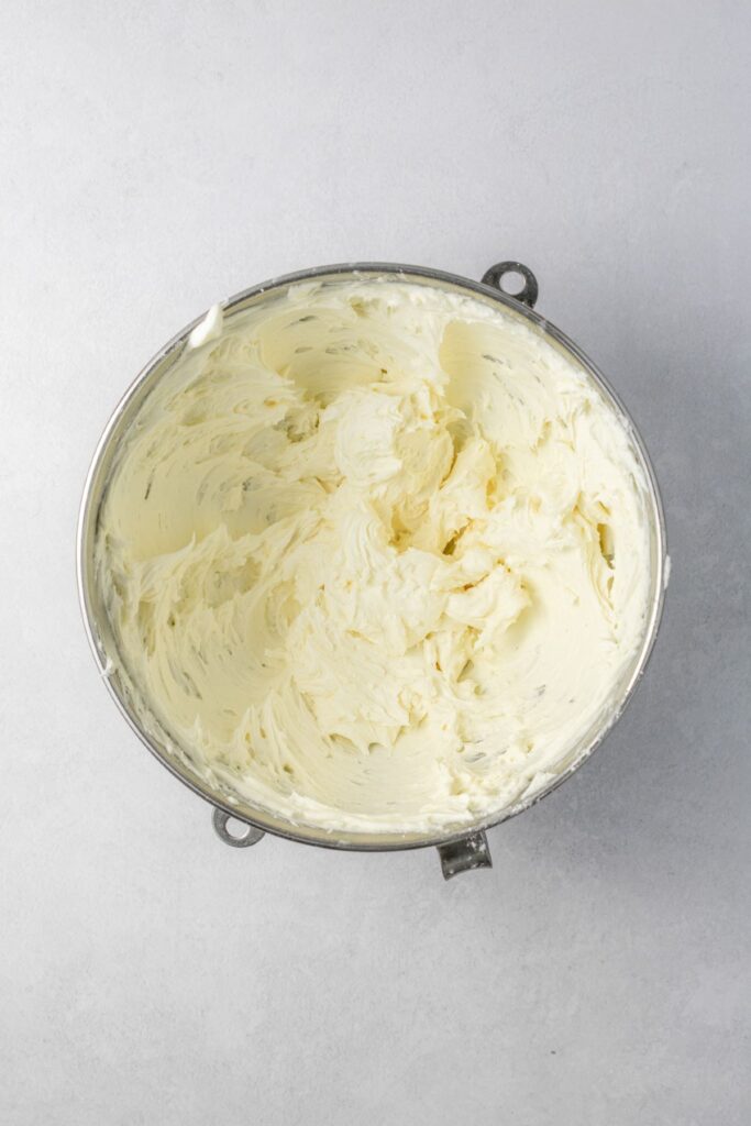 White chocolate buttercream frosting in a stainless steel bowl.