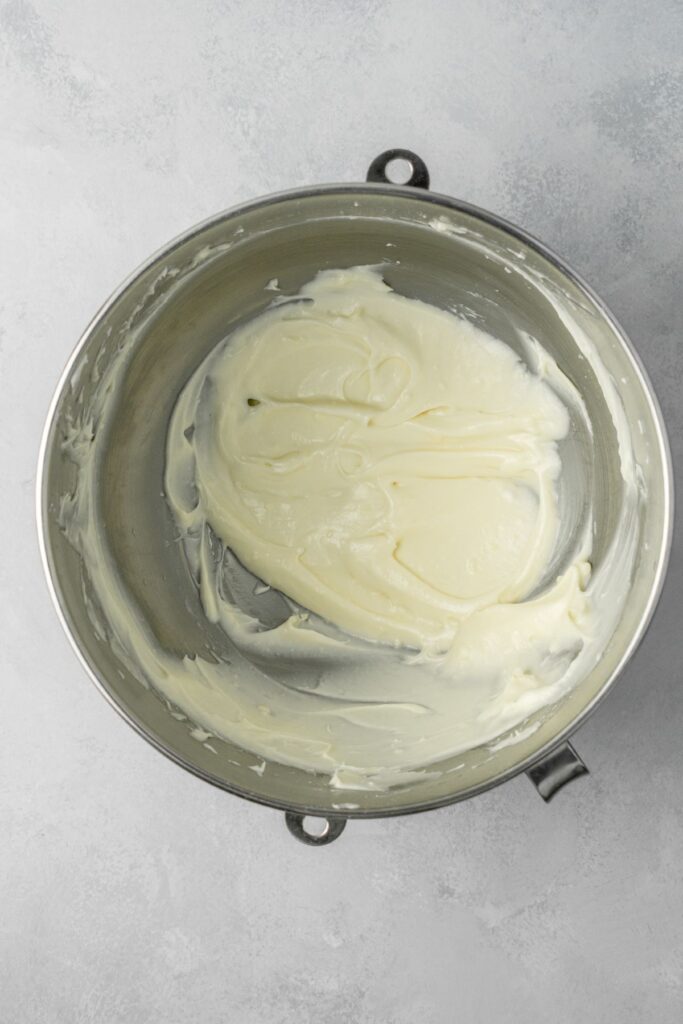 Cream cheese frosting in a stainless steel bowl.