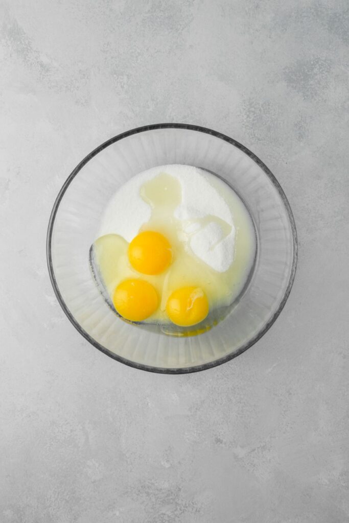 Eggs, egg yolk, and sugar in a large bowl.