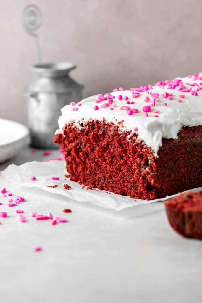 Red velvet cake that was baked in a bread pan. It's covered in frosting and sprinkles.