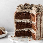 Chocolate oreo cake with oreo frosting in between the layers and oreos on top.