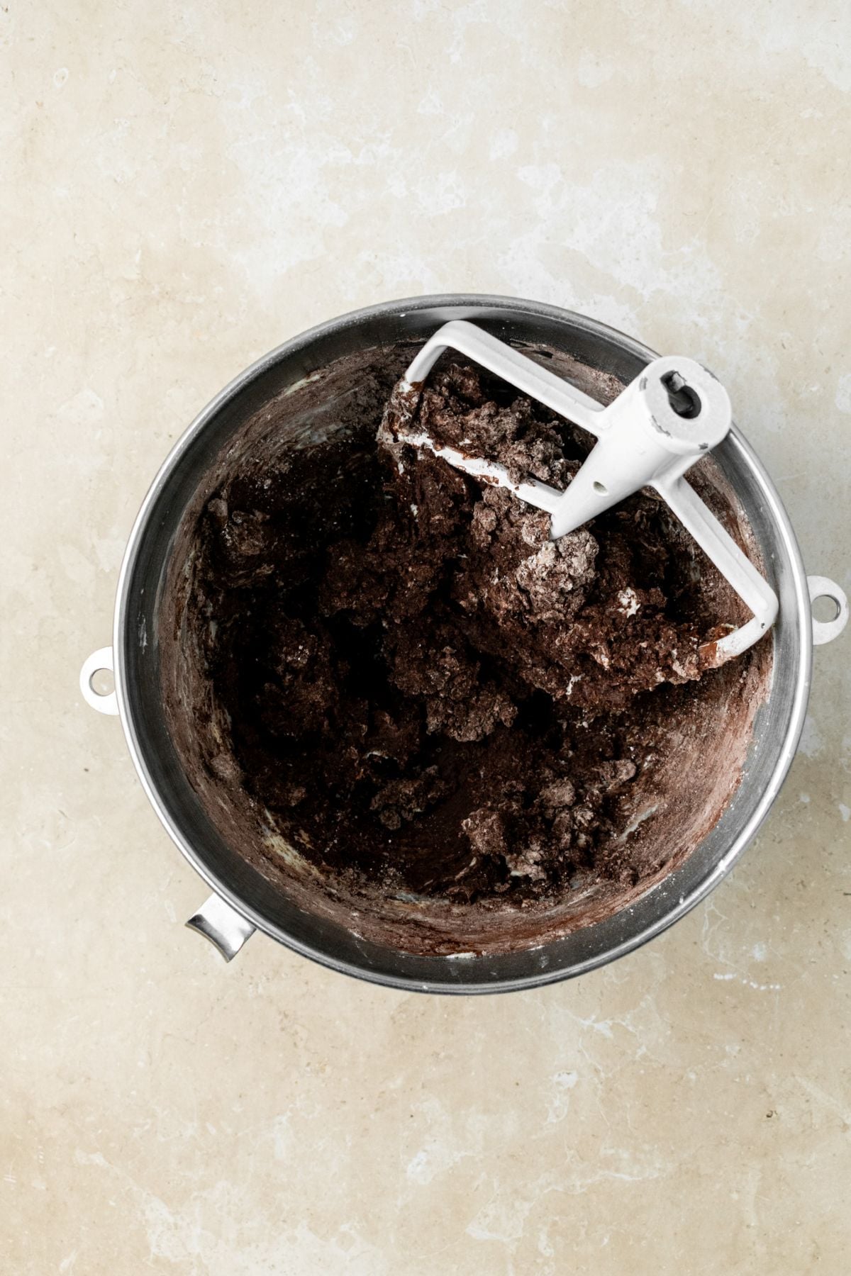 Chocolate frosting ingredients clumped together in a bowl.