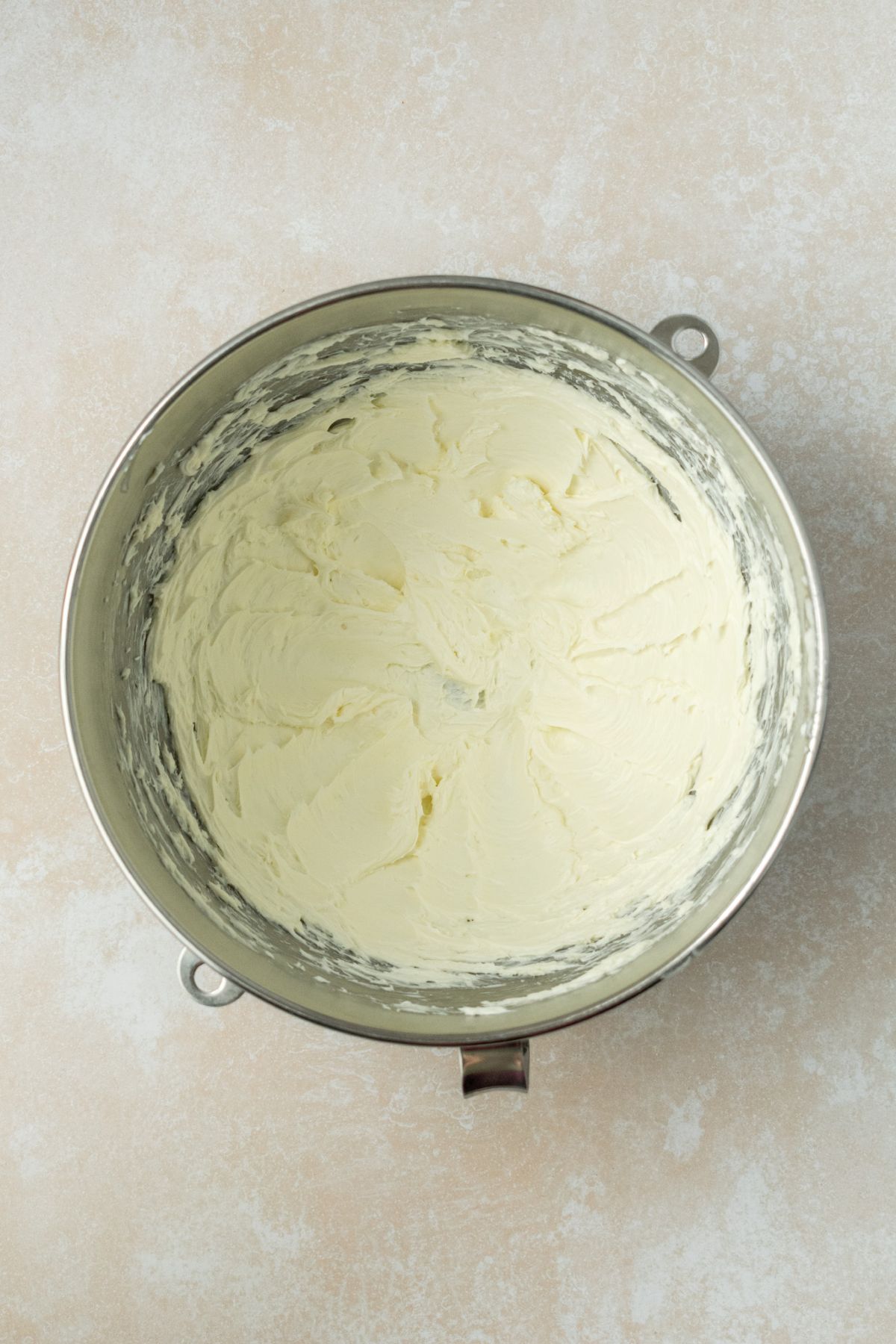 Creamed butter and cream cheese in a stainless steel bowl.