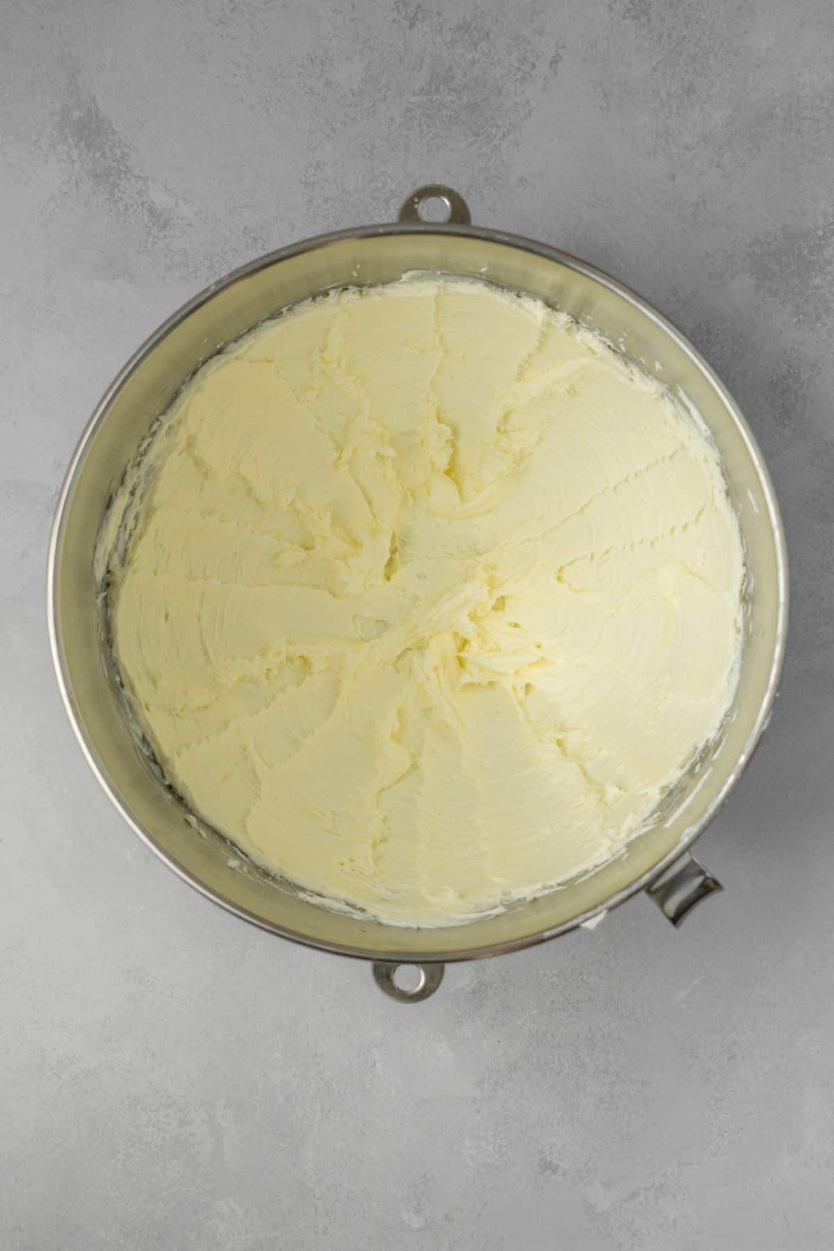 Butter and cream cheese mixed together in a large stainless steel bowl.