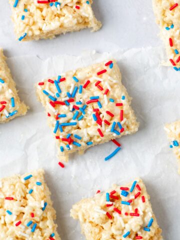 Patriotic rice krispie treat bars with red, white, and blue sprinkles on top.
