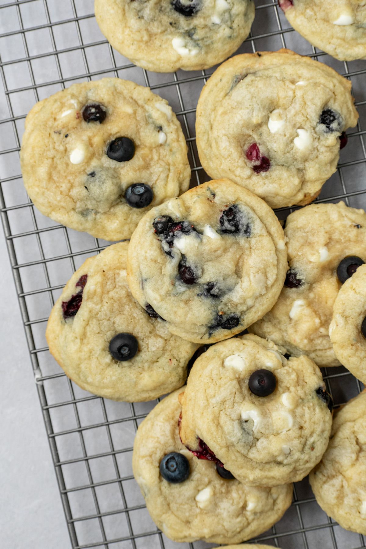 The best blueberry white chocolate cookies sitting on a wire cooling rack.