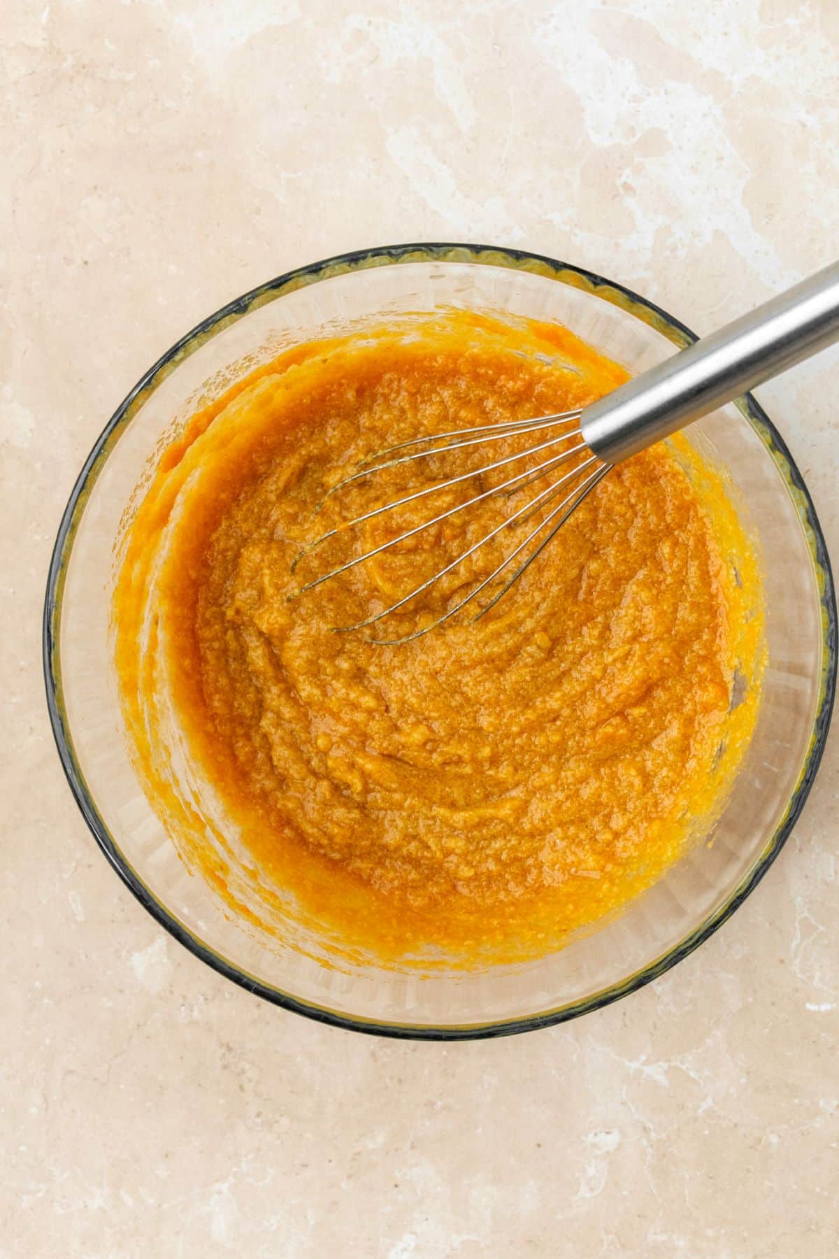 Pumpkin puree whisked into a glass bowl.