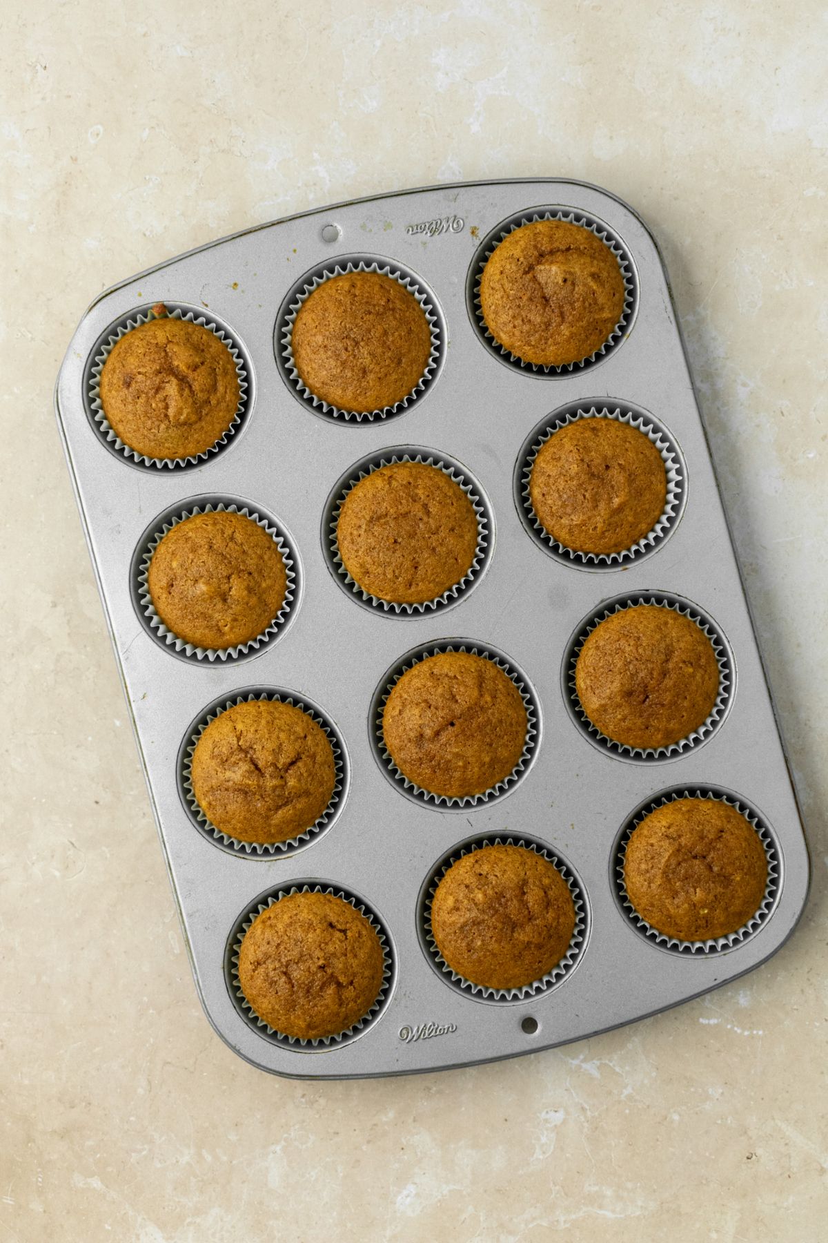 Pumpkin cupcakes in a muffin pan.