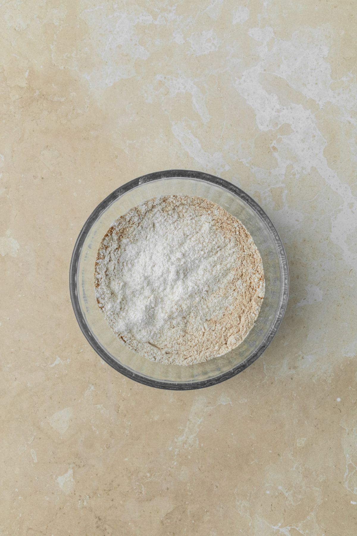 Dry ingredients for pumpkin cupcakes in a small glass bowl.