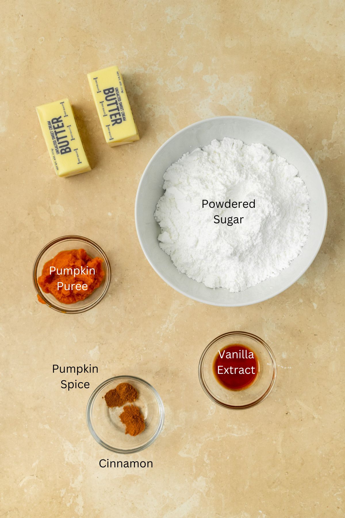 Ingredients for pumpkin frosting: powdered sugar, butter, pumpkin puree, pumpkin spice, cinnamon, and vanilla.