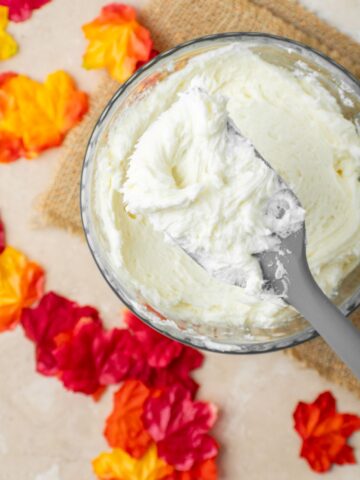 Easy 4 ingredient maple buttercream frosting with a rubber spatula holding some.