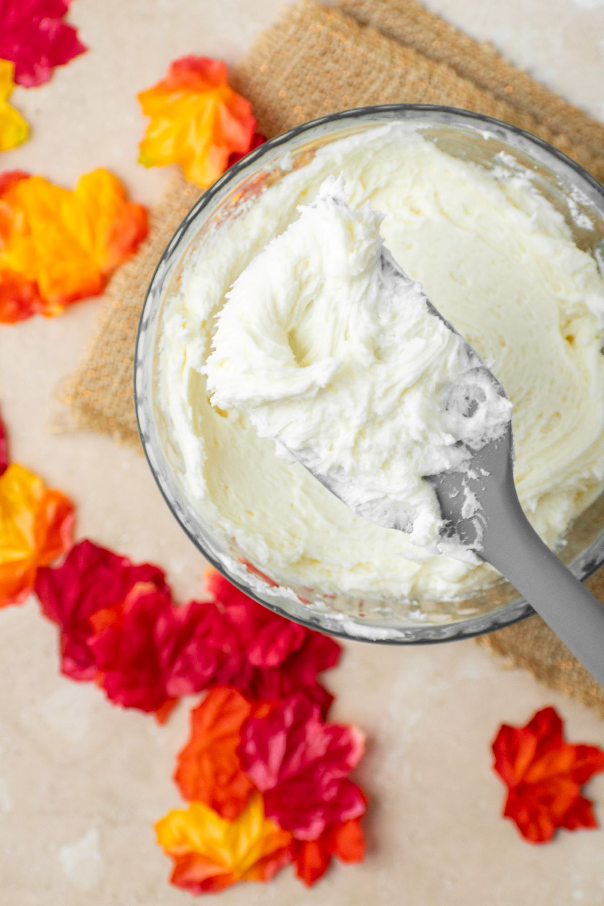 Easy 4 ingredient maple buttercream frosting with a rubber spatula holding some.