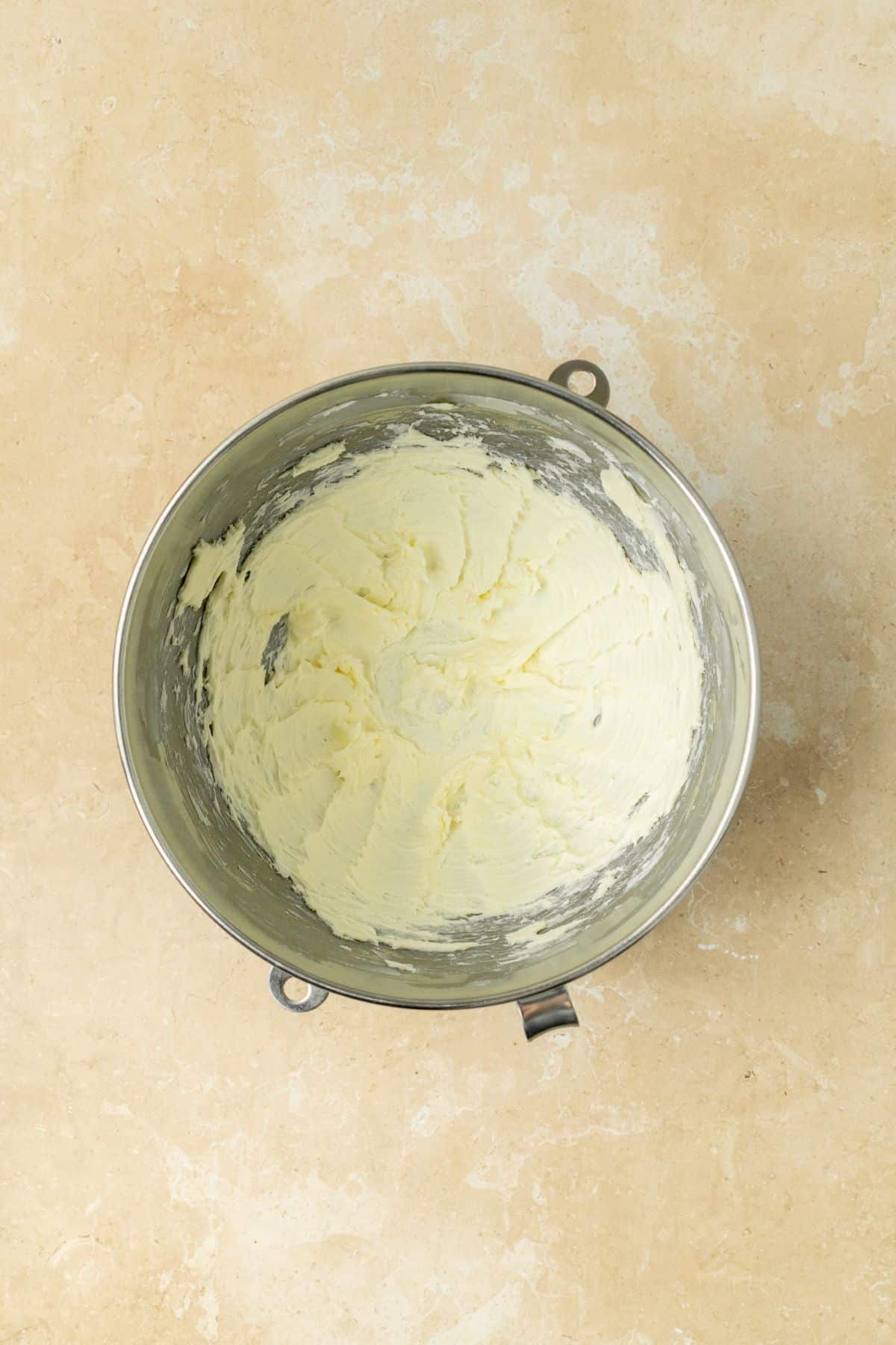 Creamed butter in a large stainless steel bowl.