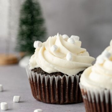 Hot cocoa cupcakes with marshmallow frosting and mini marshmallows on top.