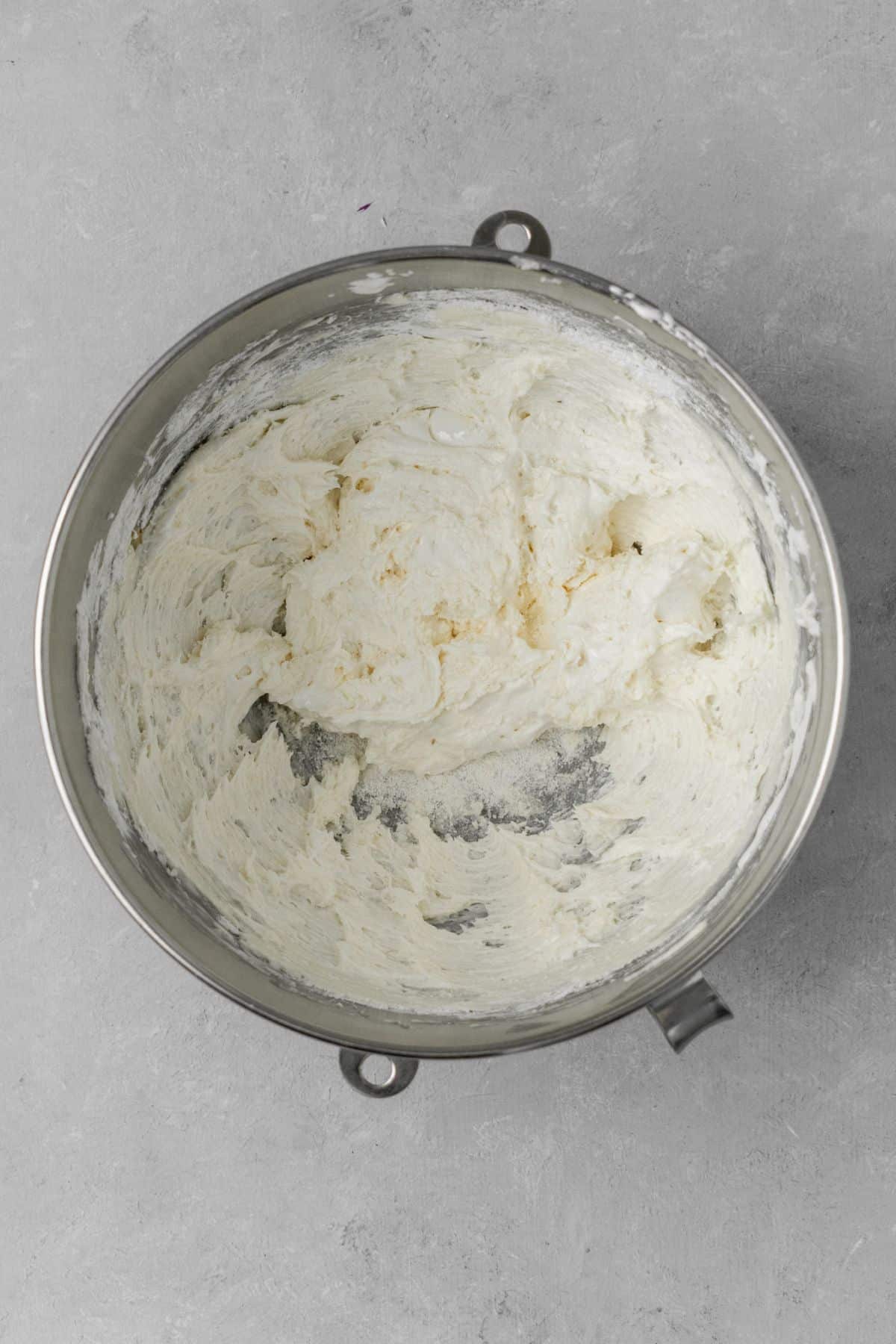 Combined ingredients of creamed butter, marshmallow fluff, powdered sugar, heavy cream, and vanilla in a large bowl.