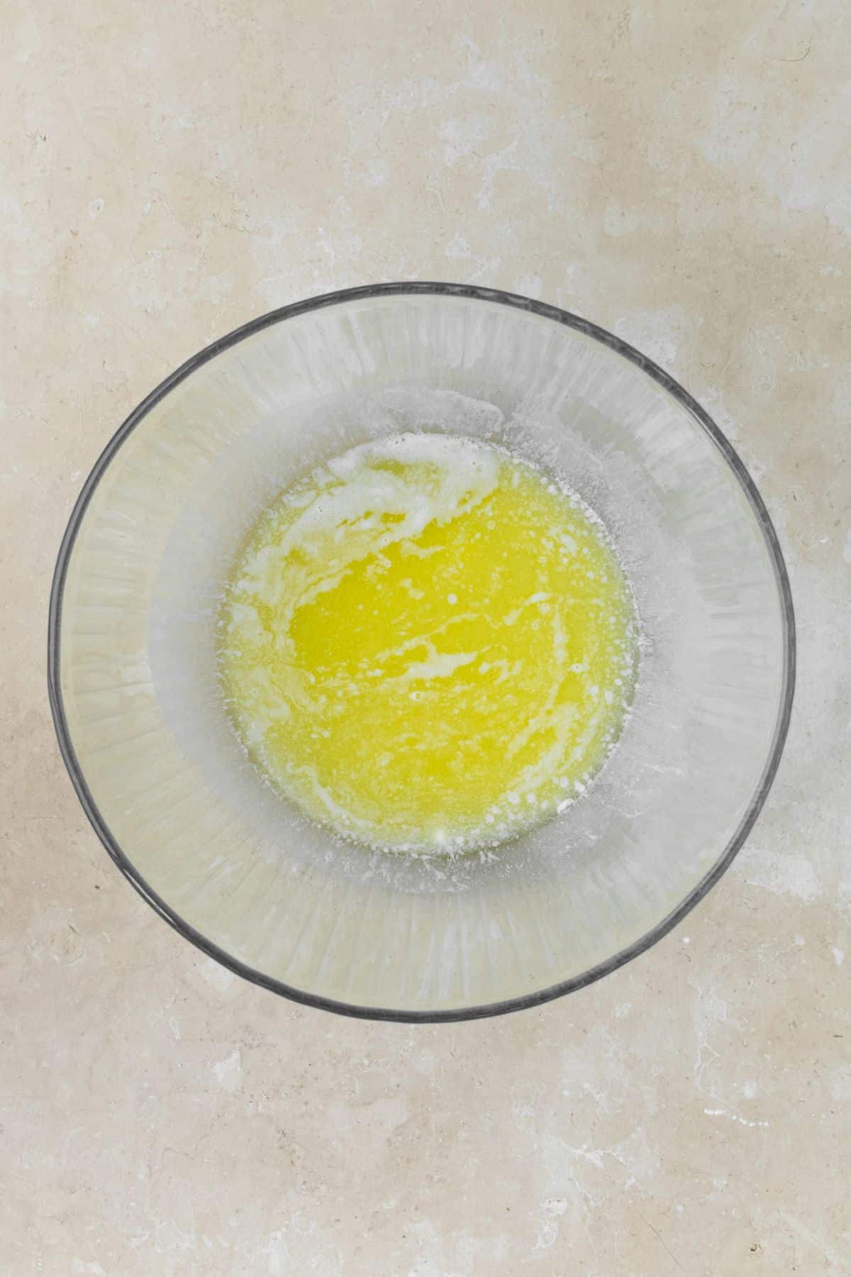 Melted butter in a large glass bowl.