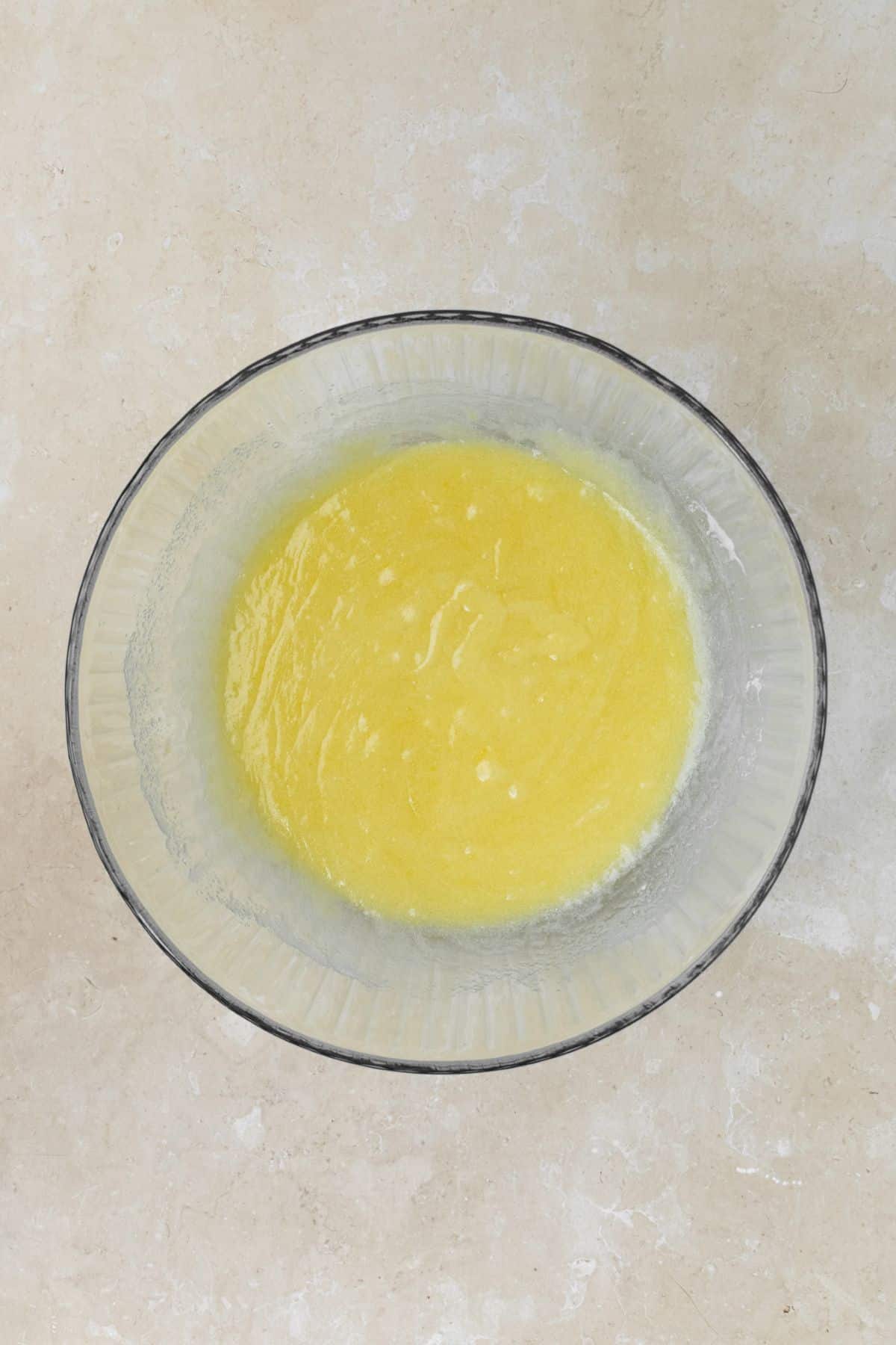 Melted butter, sugar, and eggs whisked together in a bowl.