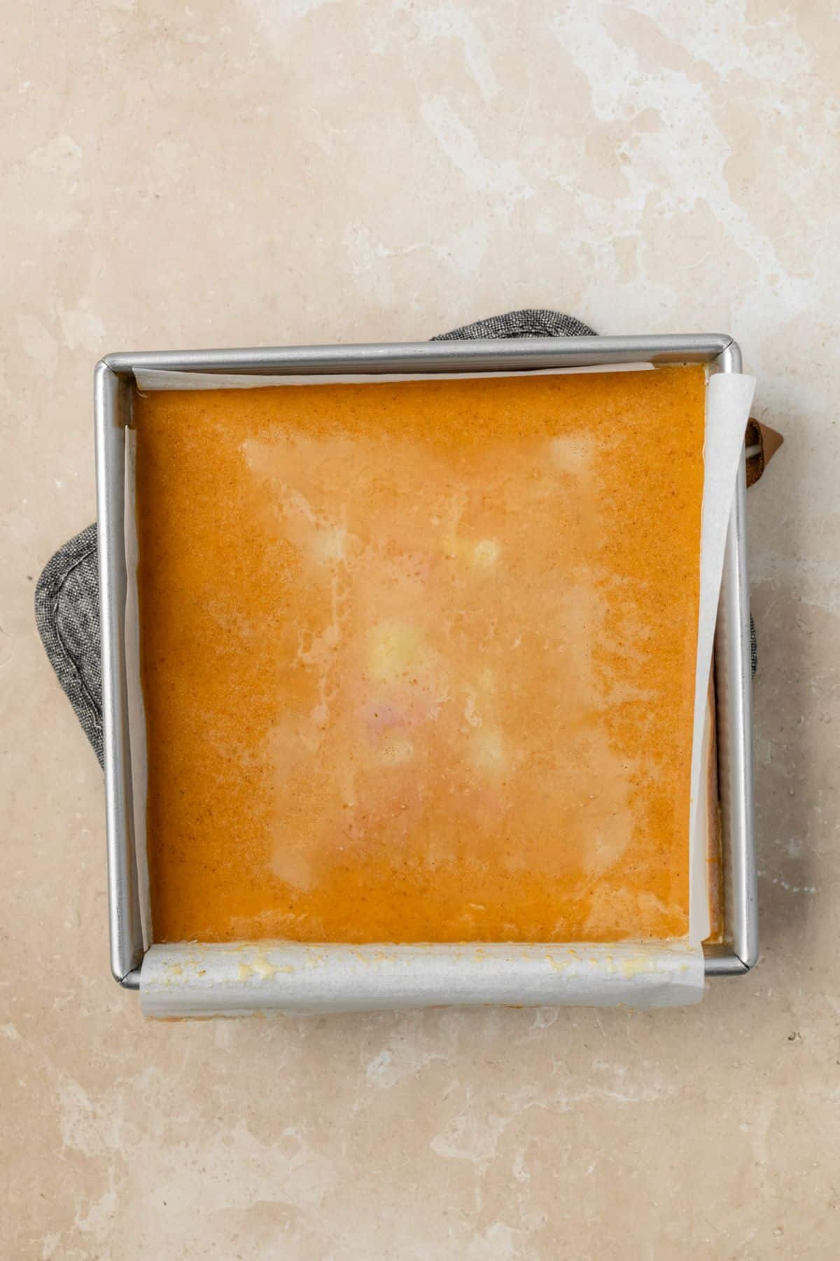 Pumpkin pie filling in a baking pan ready to be baked.