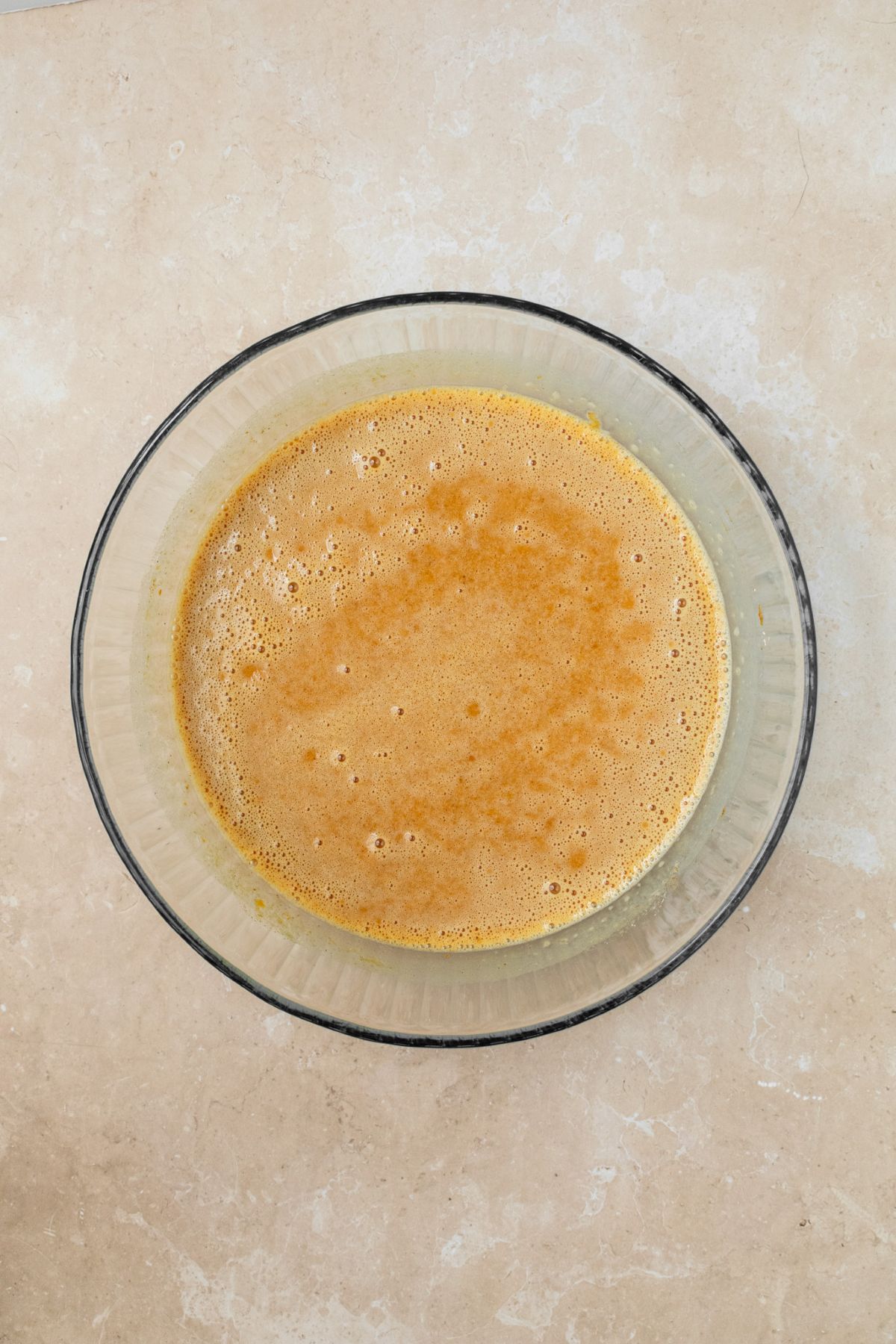 Evaporated milk whisked into the pumpkin pie filling that's in a bowl.