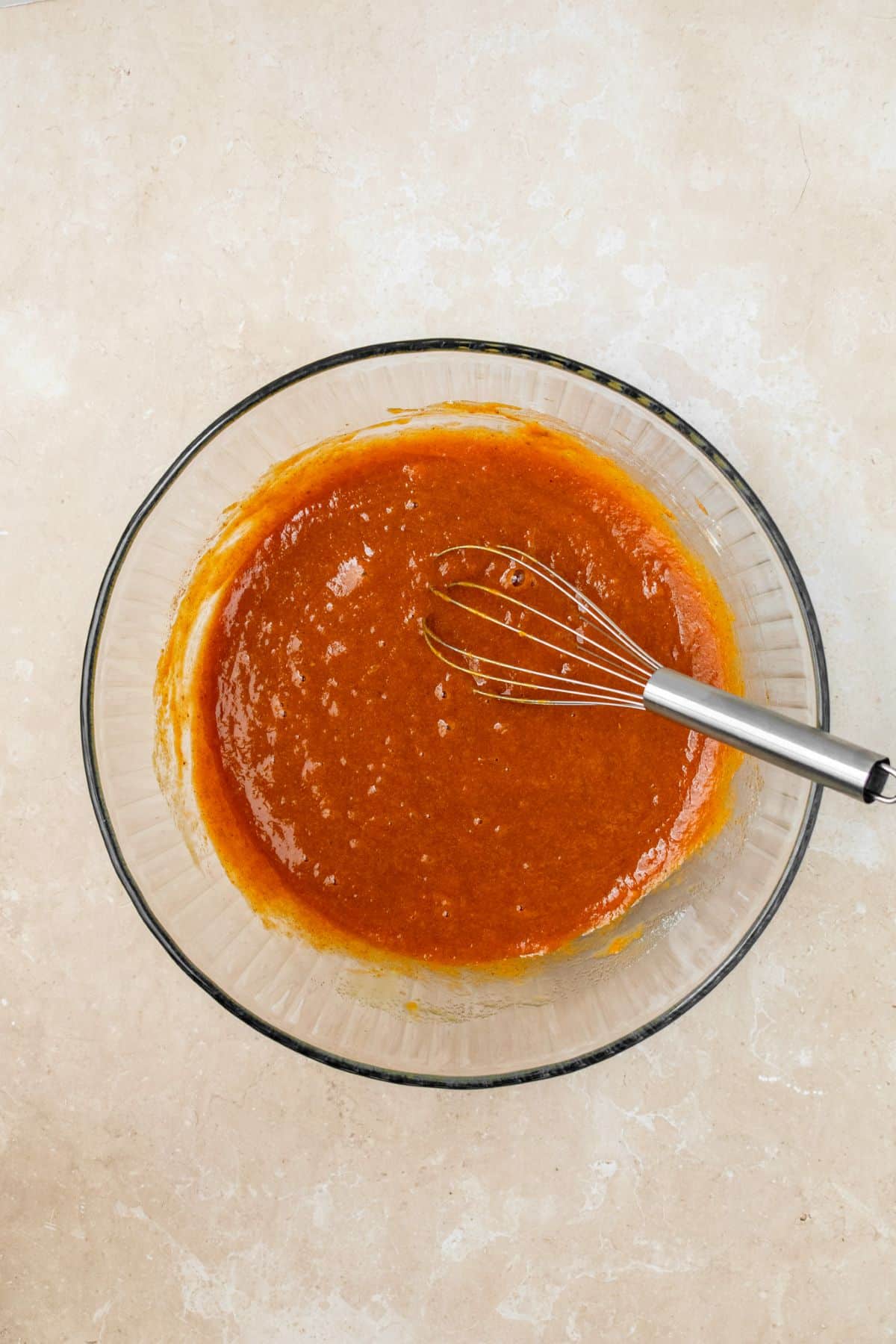 Pumpkin puree whisked in a bowl with eggs, sugar, and spices.