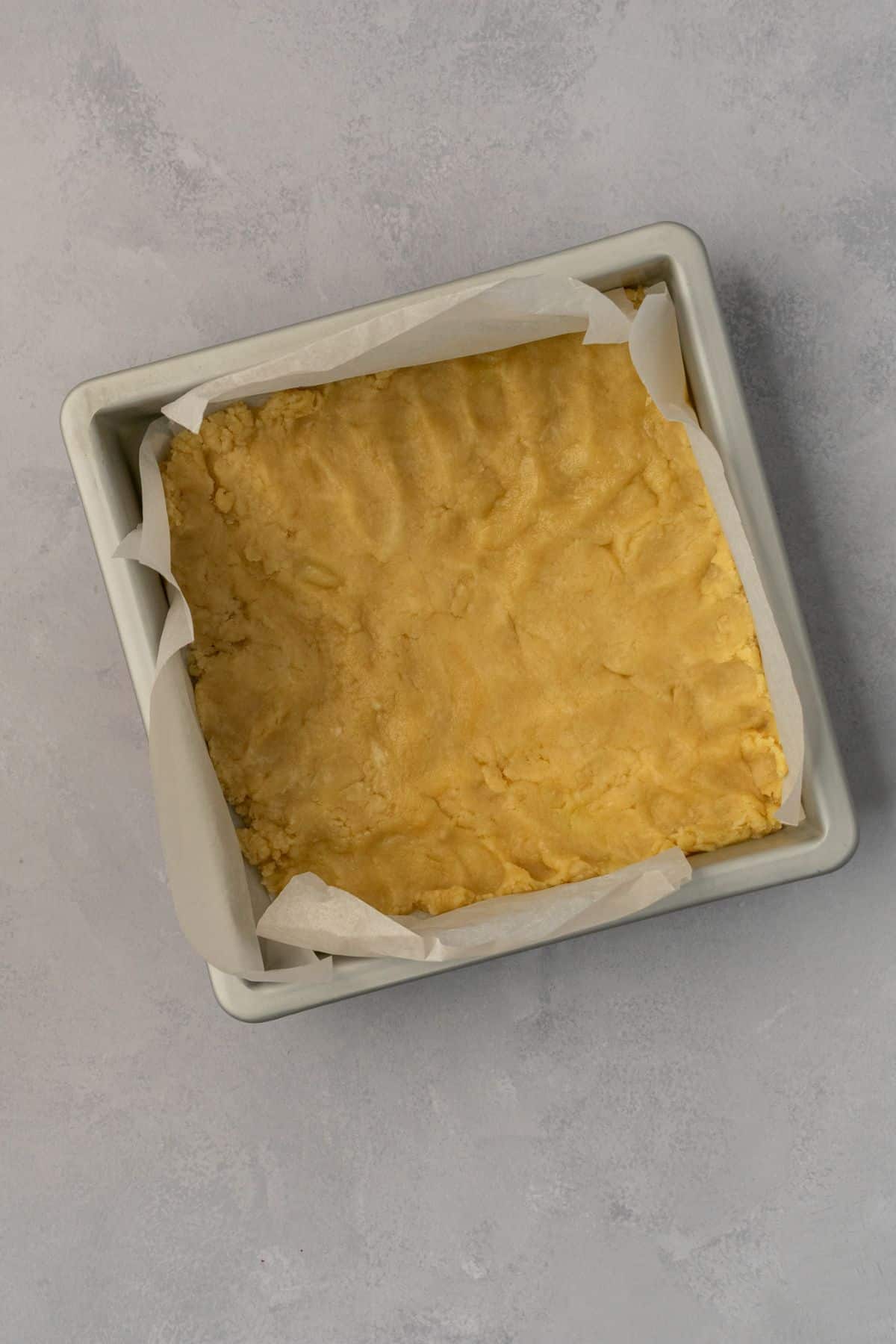 Shortbread crust pressed to the bottom of a baking pan.