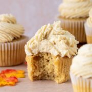 Maple cupcake topped with brown sugar frosting. A bite is taken out of one cupcake.