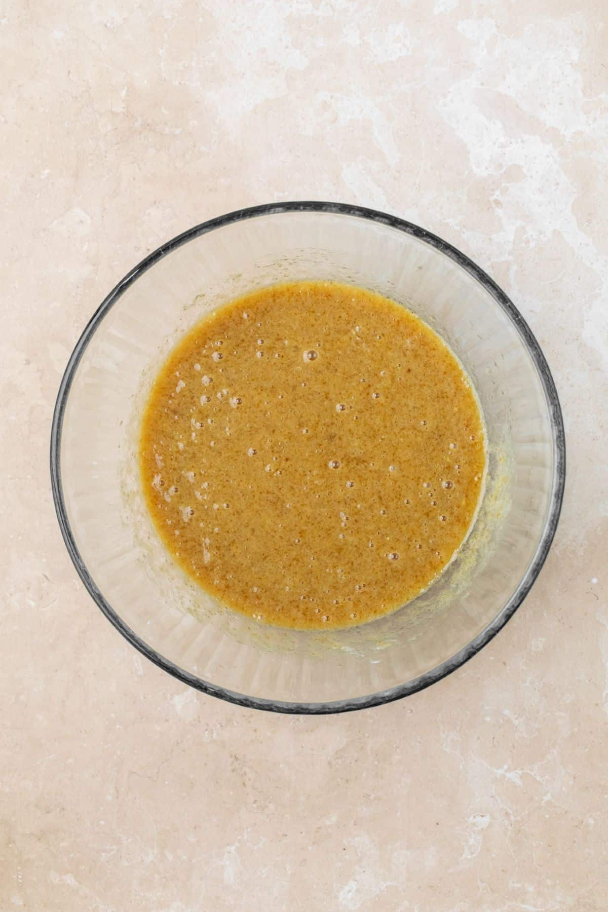 Brown sugar, oil, yogurt, and maple syrup whisked together in a bowl.