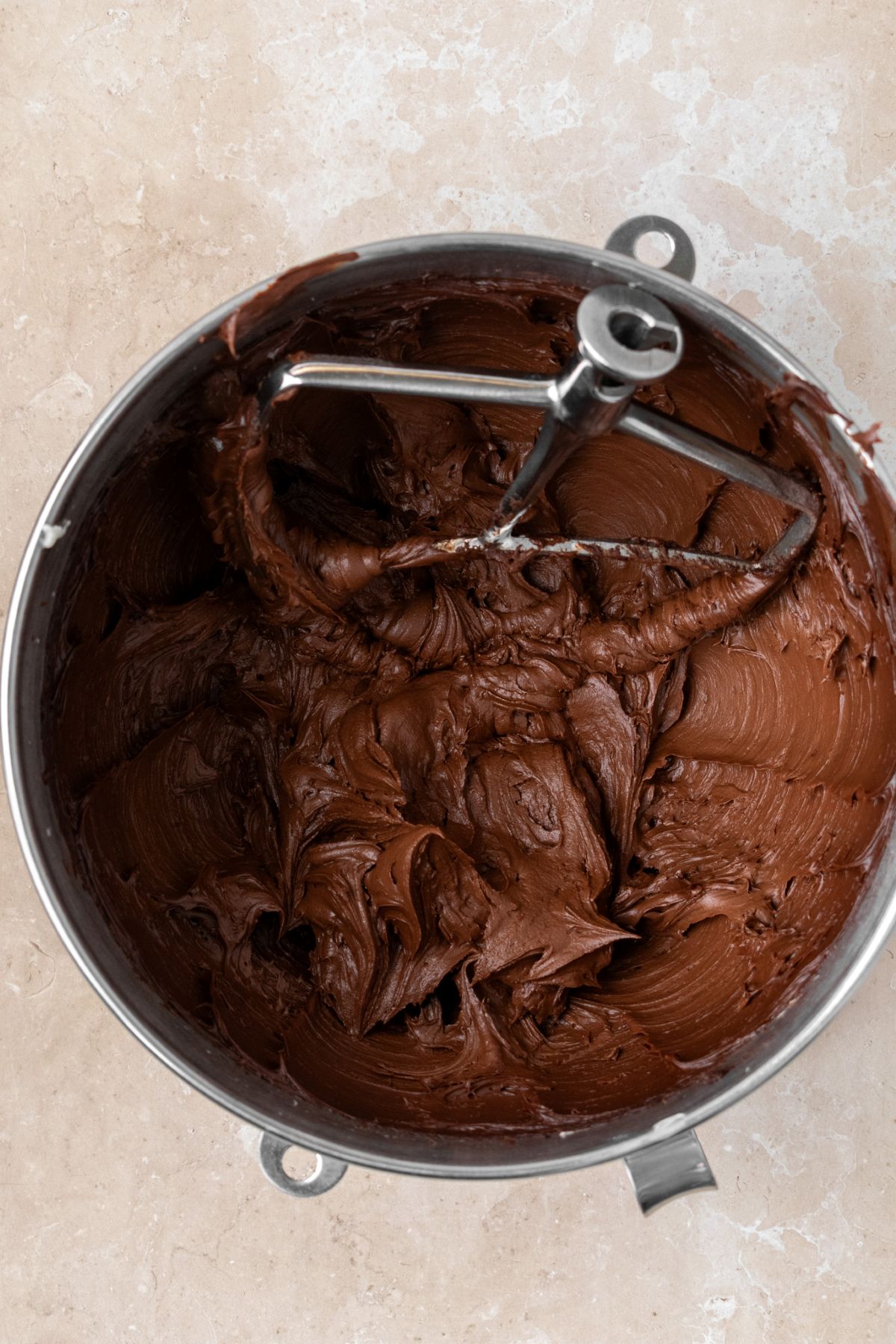 Homemade chocolate cream cheese frosting in a large mixing bowl.