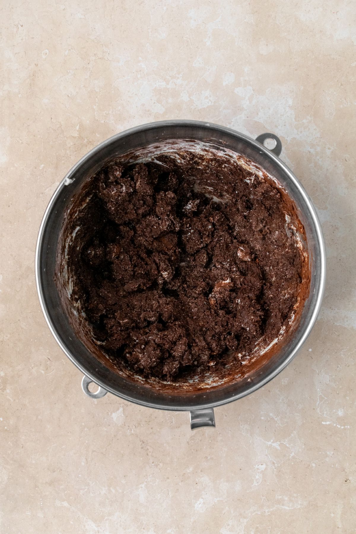 Cocoa powder, heavy whipping cream, vanilla, and powdered sugar added to whipped butter in bowl.