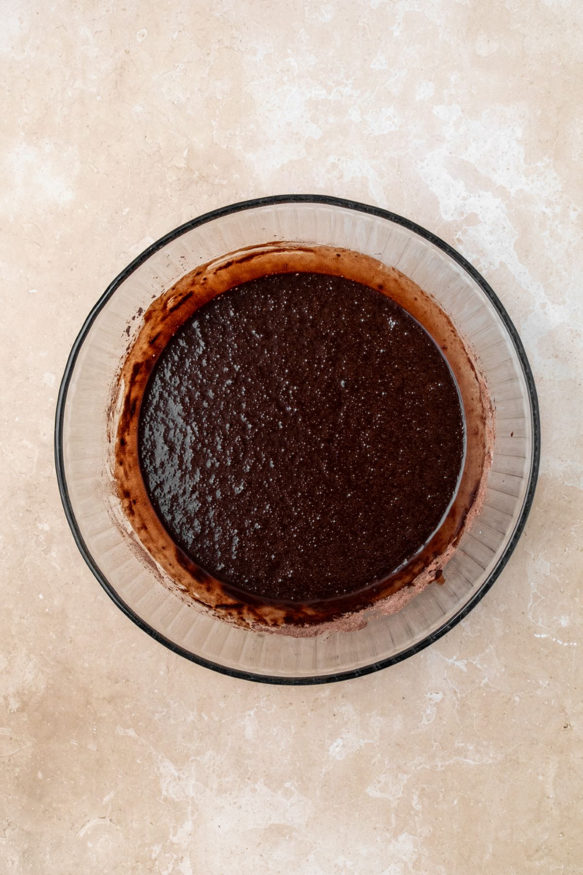 Chocolate cupcake batter in a glass bowl.