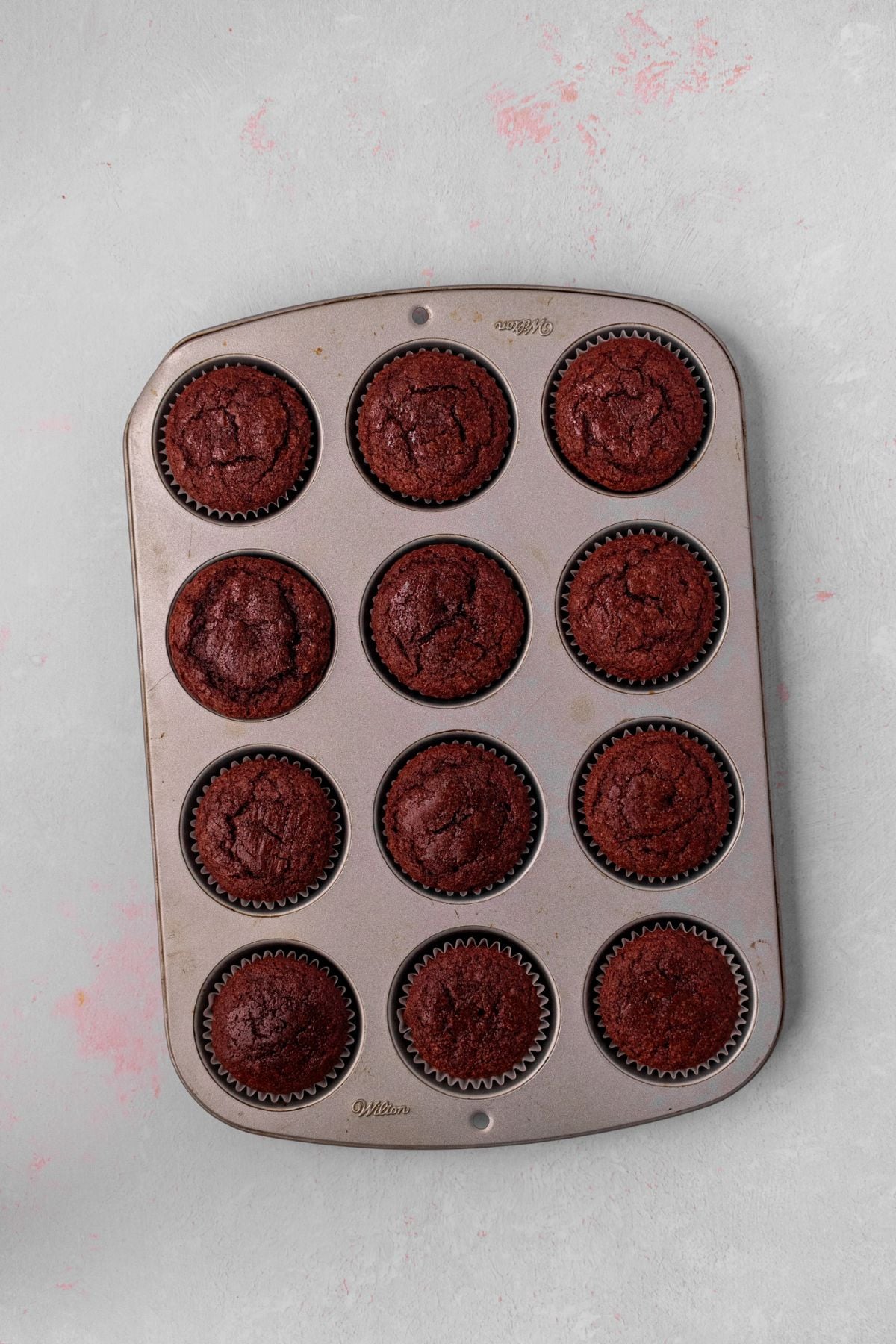 Baked red velvet cupcakes in a muffin pan.