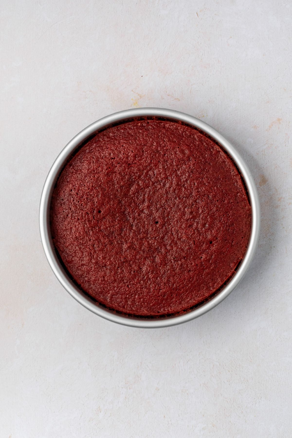 Red velvet cake in a cake pan.