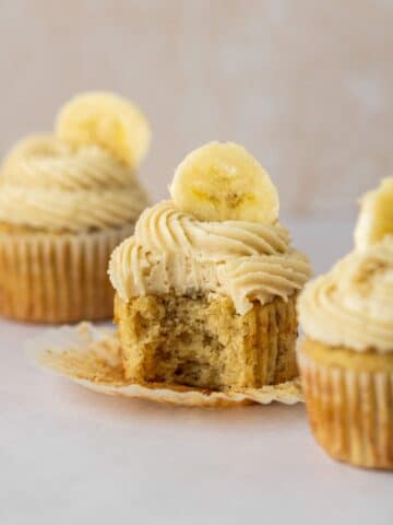 Moist and soft banana cupcakes topped with brown sugar frosting and a fresh banana slice.