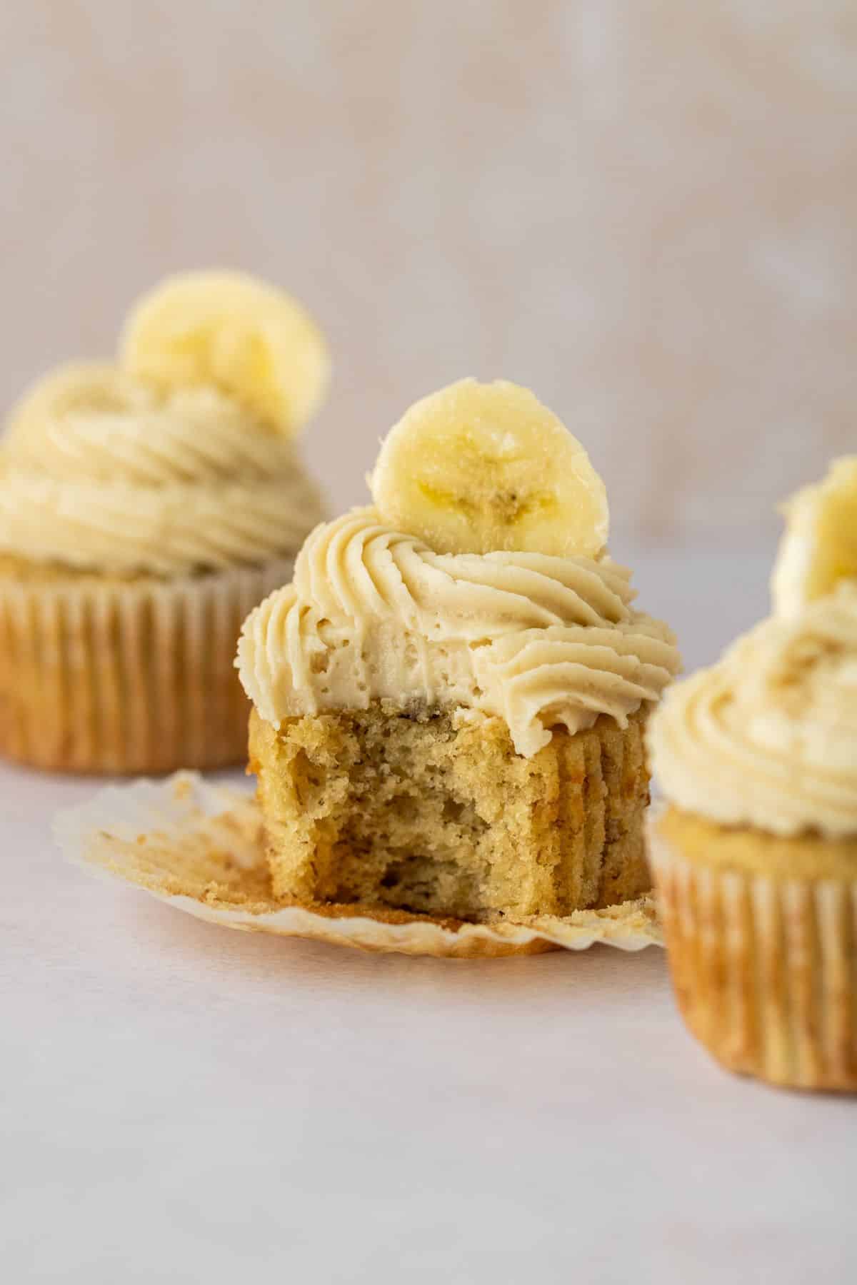 Moist and soft banana cupcakes topped with brown sugar frosting and a fresh banana slice.