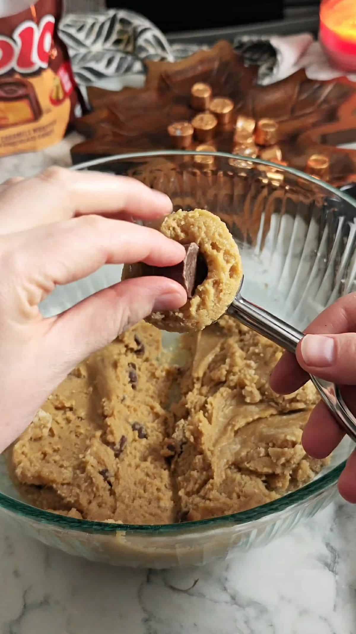 Cookie dough scoop putting a piece of candy in the middle.